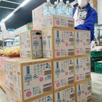 旭地域のスーパー「フレッシュイイダ」では、断水を受け出入り口付近に水を用意した＝２２日、旭市