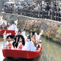川岸にはカメラを手にした観光客らが集まり、華やかなパレードを楽しんでいた＝５日、香取市
