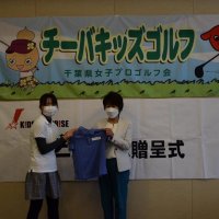 キッズサプライズジャパンから贈られたポロシャツを手にする参加者（左）