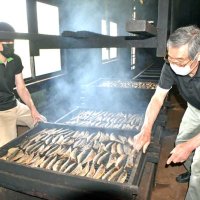 サバの薫製作業に汗を流す４代目の吉田勇二さん（左）と先代の仁一郎さん。いぶして硬くなったサバはカビ付けと天日干しを経て味わい深いさば節となる＝１日、館山市の吉田商店