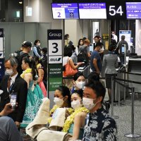 ハワイ便が再開したフライングホヌに乗る客でにぎわう搭乗口＝１日午後７時４５分ごろ、成田空港
