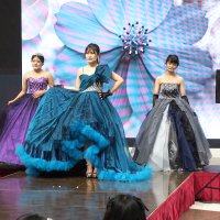 スクリーンのイメージに合わせてドレス姿を披露した木更津東高生のファッションショー＝木更津市