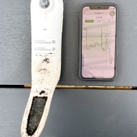土壌に入れて使う野菜栽培監視センサー（左）。スマホ（右）のアプリで生育環境を把握できる