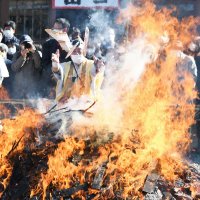 燃えさかる炎の中に納められた札を投げ入れる成田山新勝寺の僧侶＝２８日、成田市
