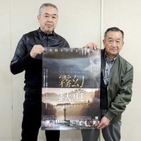 映画「霧幻鉄道　只見線を３００日撮る男」のポスターを手にする安孫子監督（左）と柏市ふるさと交流協会の嶋田会長＝同市役所