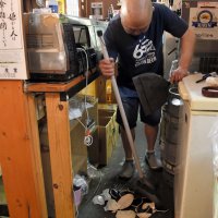 地震で落ちた皿を片付け、開店準備をする飲食店の店主＝１１日午前９時５５分ごろ、木更津市