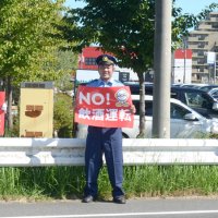 国道１２６号沿いで飲酒運転防止を訴えるパネルを持つ永田選手（中央）