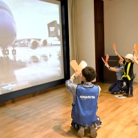 パドルを持ち、巨大スクリーンに映し出された航空機の誘導にも挑戦