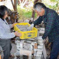 乾燥させた芝原人形を窯に入れる千葉惣次さん（右）と真理子さん＝１１月２９日、長南町