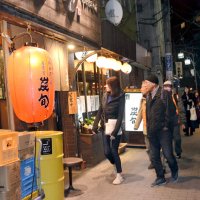 赤ちょうちんの提がる飲食店街を歩く参加者たち＝船橋市