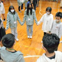 手をつないでゲームを楽しむ睦沢小の児童と台湾の児童
