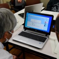 模範解答と照らし合わせて記述式の採点を行う教員