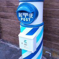 斜めラインがデザインされた家の田踏切そばの丸型ポスト
