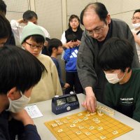 対局後、将棋の木村九段から指し手のアドバイスを受ける小学生＝３１日、成田市