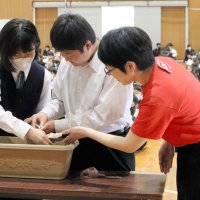 高田さんに見守られながら、朝顔の種を植える二宮中学生の生徒
