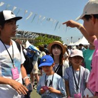 地元大学生のガイド（右）が会場内を周りながら、フェスの楽しみ方を伝授した