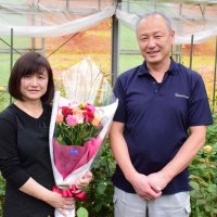 バラの栽培管理をする米田さんと花束を仕立てている妻の静江さん
