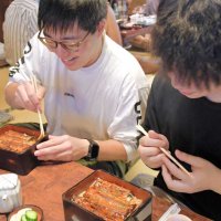 土用の丑の日となった２４日、開店したばかりの川豊の店内でうな重を楽しむ人たち＝成田市