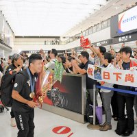 成田空港に凱旋し、大勢のファンに出迎えられるレスリングの文田（手前）らパリ五輪のメダリストたち
