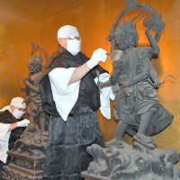 本尊不動明王の両脇に立つ四大明王をはけで払う成田山新勝寺の僧侶＝１３日、成田市
