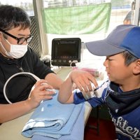 船橋整形外科と連携し、肘の状態をチェックしてもらう少年野球の球児＝船橋市運動公園野球場
