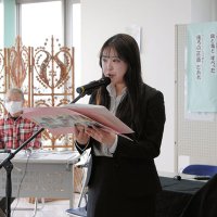 旭市での自らの震災体験をつづった文章「この街の未来のために」を朗読する佐久間さん＝１１日、旭市上永井の飯岡刑部岬展望館