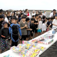 ずらりと並べられた景品の前に立つ子どもら＝１２日、いすみ市