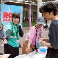 来場者にイベントの内容を案内するＮＰＯスタッフ＝９月１４日、同区の「ＧＬＯＢＯ」