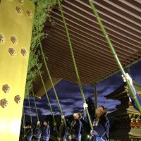 成田山新勝寺の大本堂の軒下でササ竹を揺すってすす払いをする職員＝１３日午前５時５５分ごろ、成田市