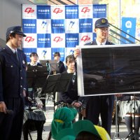 高校生も参加した１１０番通報の実演の前に、交通事故時の通報の仕方を紹介する警察官＝８日、千葉市中央区のきぼーる