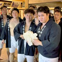 真っ二つに割れた鏡餅を披露する男衆たち＝１１日、流山市