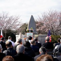 慰霊祭であいさつする「黒船『ハーマン号』を世に出す会」の照川会長＝１３日、勝浦市