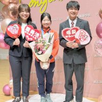 同じ勇志国際高のフィギュアスケーター、池田立選手（右）から贈られた花束を手に笑顔を見せる中井選手（中央）＝流山市