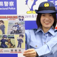県警の青山本部長がデザインしたクリアファイルを紹介する女性警察官＝２０日、千葉市中央区の県警本部