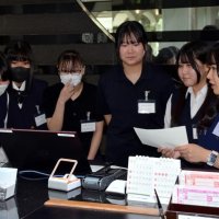 フロント業務についてスタッフ（右端）から説明を受ける生徒＝市原市の米原ゴルフ倶楽部
