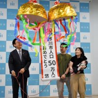 くす玉を割る真境名悠吾ちゃんの両親と田中市長＝８日、市川市役所