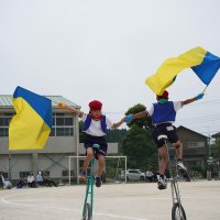 大きな一輪車を上手に乗りこなして技を披露する児童
