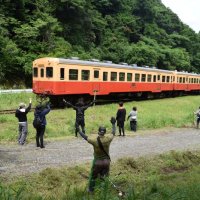 除草作業の手を休め小湊鉄道の乗客らに手を振る参加者＝１３日、市原市