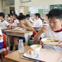 特産の新タマネギがふんだんに使われた給食をほおばる児童ら＝１６日、白子町の白潟小学校（画像の一部を加工しています）