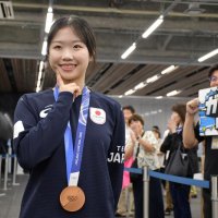拍手に迎えられ交流会場に向かう際、五輪で話題になったポーズを決める中井さん