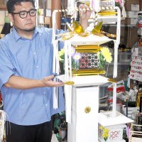 房州切子を持ち上げ、下部の袴（はかま）を含めた全体を見せる中村さん＝２９日、館山市
