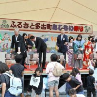 五穀豊穣式典では平山町長や土井さんがステージ上から多古米や菓子を振る舞った＝７日、多古町