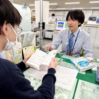 出生届の名のフリガナについて、名付け辞典を手に窓口で説明する北川さん＝６月上旬、船橋市役所
